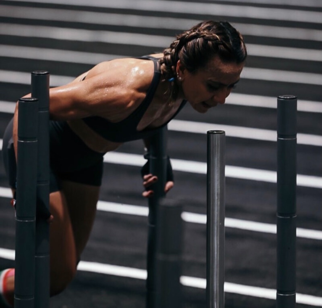 Dina leaning into a race station in black kit