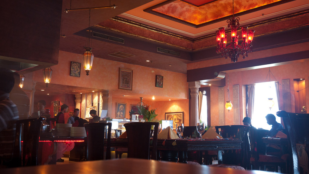 A cosy, warmly lit Jakarta restaurant — chandeliers, set tables and people lingering over dinner